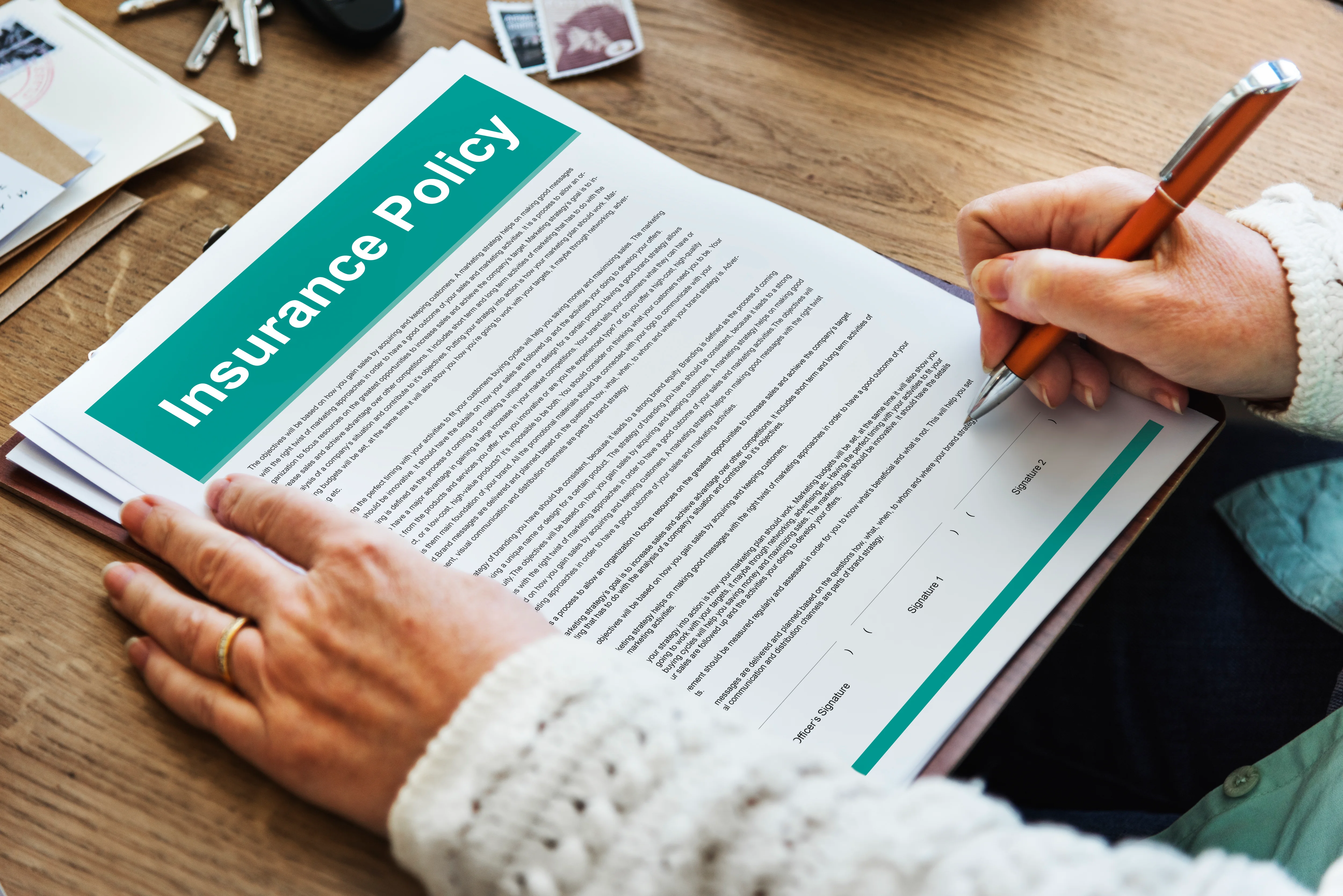 Close up of man reading insurance policy agreement terms and signing paper