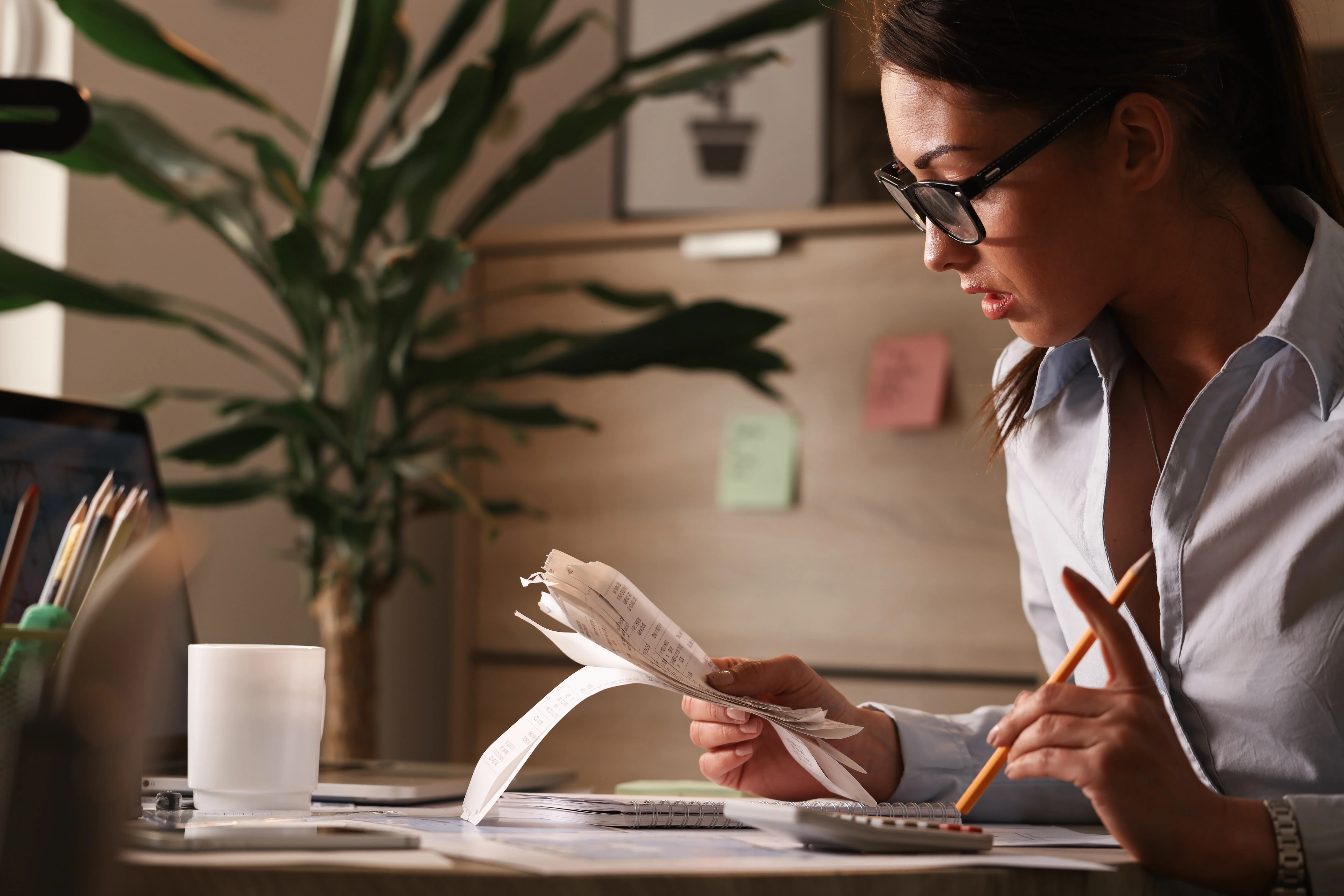 Female accountant reviewing receipts and calculating expenses for tax deductions and financial planning