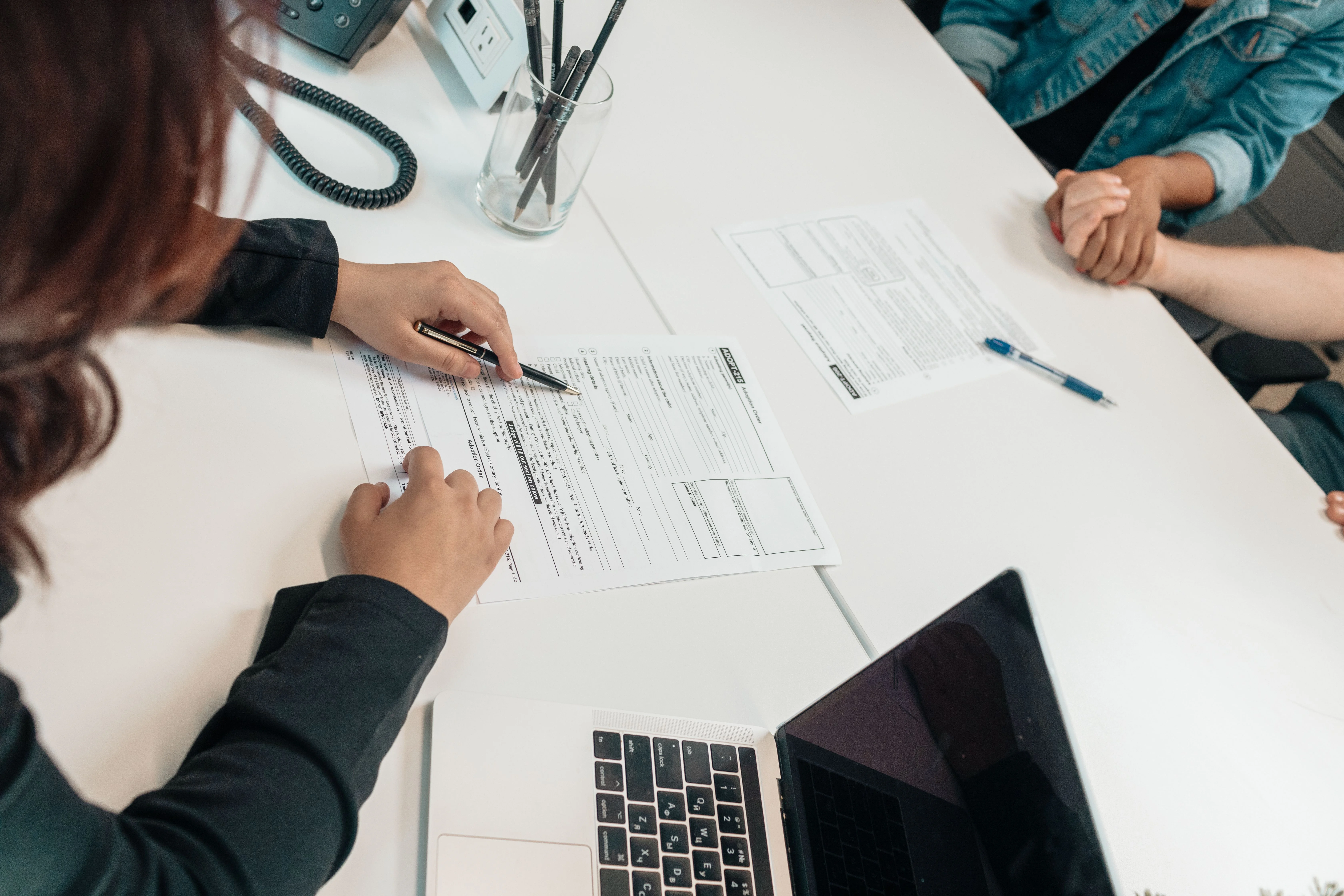 Insurance representative reviewing health insurance application forms with a client