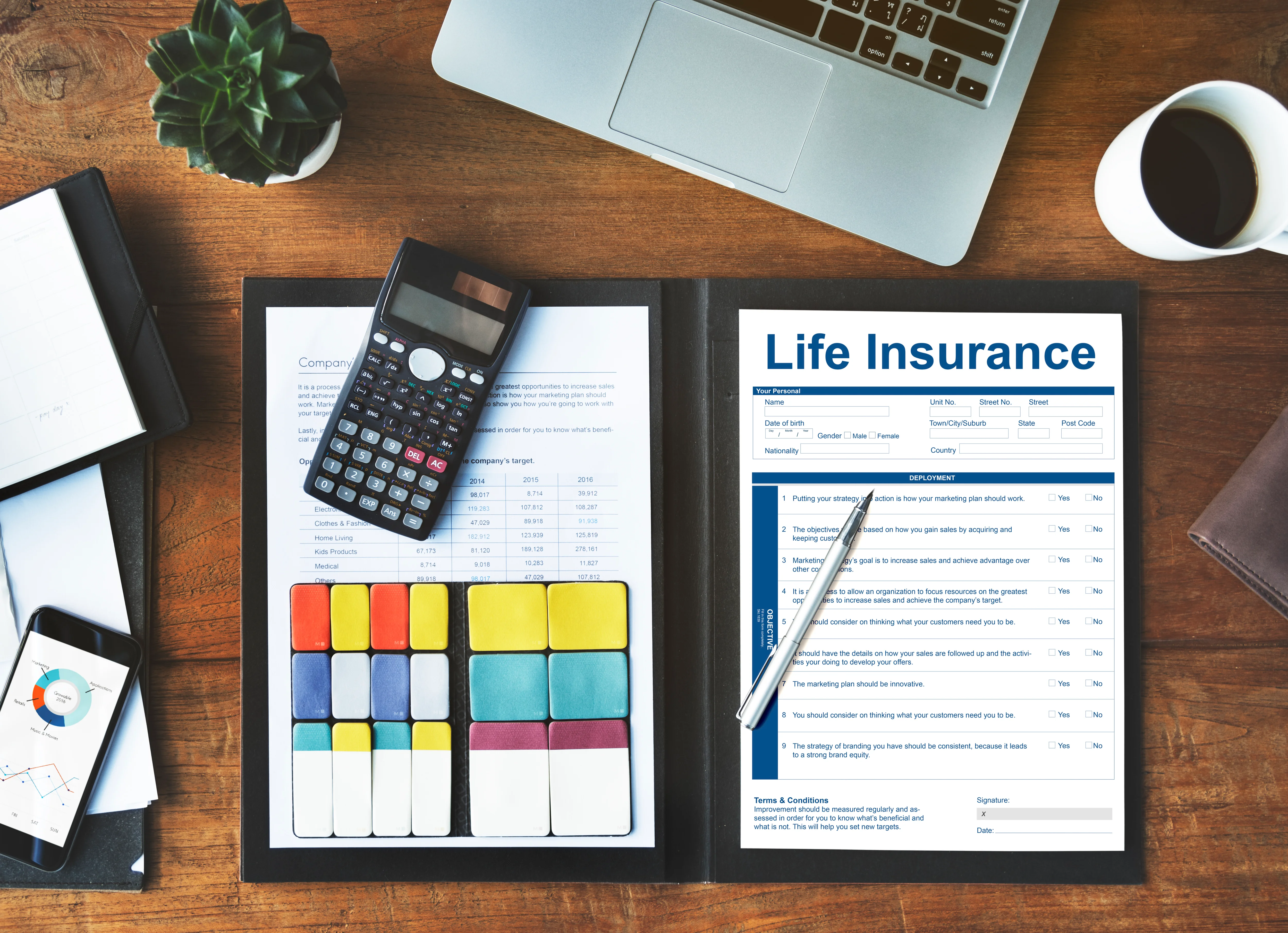 Top down view of desk with life insurance policy form and office supplies